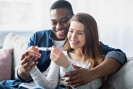 Young couple smiling at pregnancy test results